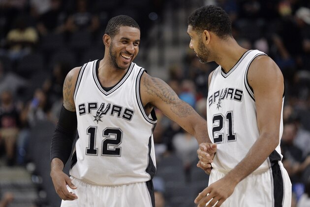 San Antonio Spurs' LaMarcus Aldridge (12) laughs with teammate Tim Duncan during the second half of a preseason NBA basketball game against the Detroit Pistons, Sunday, Oct. 18, 2015, in San Antonio. (AP Photo/Darren Abate)