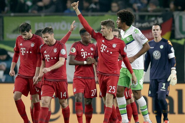 Bayern's Thomas Mueller, front, gives a thumb up as he celebrates scoring his side's third goal during the German soccer cup second round match between VfL Wolfsburg and FC Bayern Munich in Wolfsburg, Germany, Tuesday, Oct. 27, 2015. (AP Photo/Michael Sohn)