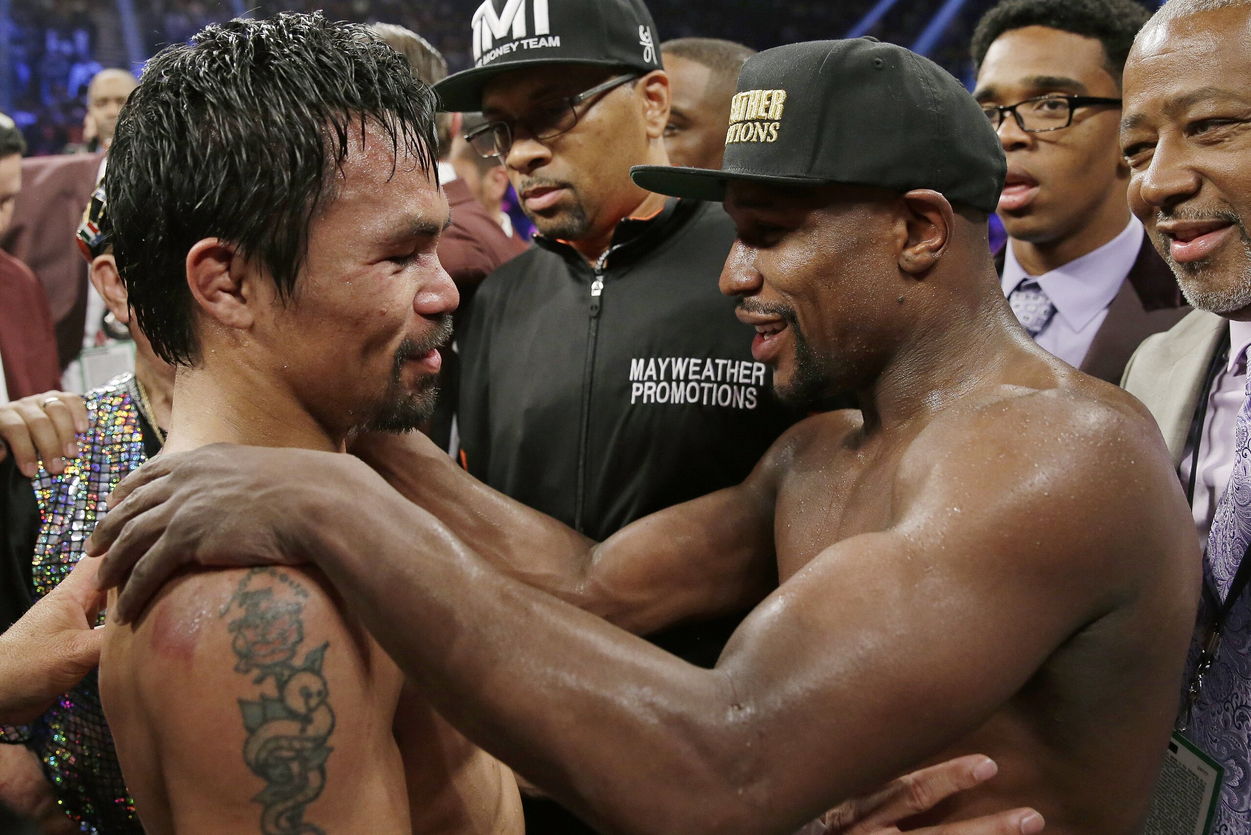 FILE - This May 2, 2015 file photo shows Manny Pacquiao, from the Philippines, left, and Floyd Mayweather Jr., embrace in the ring at the finish of their welterweight title fight in Las Vegas. Boxing fans across the country or at least their lawyers are calling the hyped-up fight between Pacquiao and Mayweather a fraud. Some 31 class action lawsuits had been filed through Friday alleging primarily the same thing: that Pacquiao's pre-existing shoulder injury should have been disclosed to fans ahead of time. (AP Photo/Isaac Brekken,File)