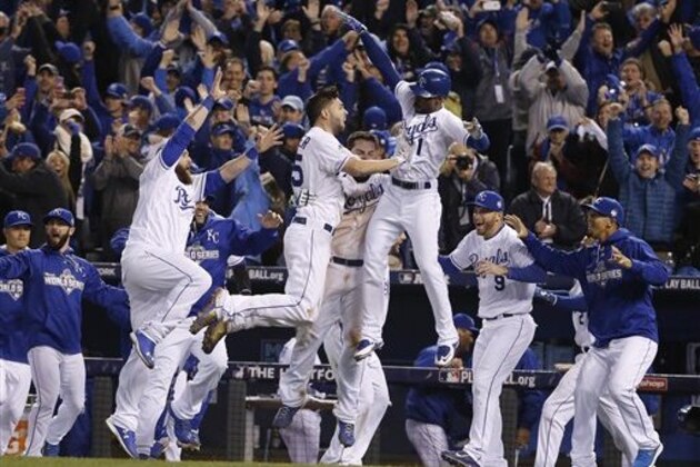 Kansas City Royals players celebrate after Alcides Escobar scored on a sacrifice fly by Eric Hosmer during the 14th inning of Game 1 of the Major League Baseball World Series against the New York Mets Wednesday, Oct. 28, 2015, in Kansas City, Mo.  (AP Photo/Matt Slocum)