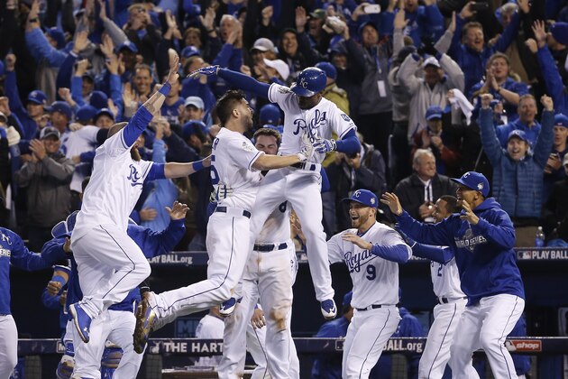 Kansas City Royals celebrate after Alcides Escobar (2) scored on a sacrifice fly by Eric Hosmer during the 14th inning of Game 1 of the Major League Baseball World Series against the New York Mets Wednesday, Oct. 28, 2015, in Kansas City, Mo.  (AP Photo/Matt Slocum)