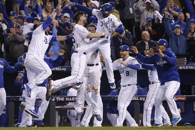 Kansas City Royals celebrate after Alcides Escobar (2) scored on a sacrifice fly by Eric Hosmer during the 14th inning of Game 1 of the Major League Baseball World Series against the New York Mets Wednesday, Oct. 28, 2015, in Kansas City, Mo.  (AP Photo/Matt Slocum)