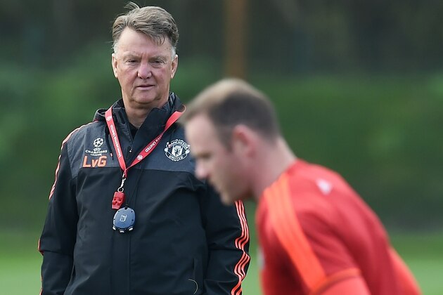Manchester United's Dutch manager Louis van Gaal (L) watches English striker Wayne Rooney (R) work during a training session their Carrington facility in Manchester, north west England on October 20, 2015 ahead of their Champions League football match against CSKA Moscow on October 21. AFP PHOTO / PAUL ELLIS        (Photo credit should read PAUL ELLIS/AFP/Getty Images)