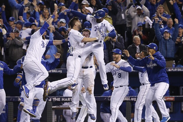 Kansas City Royals celebrate after Alcides Escobar (2) scored on a sacrifice fly by Eric Hosmer during the 14th inning of Game 1 of the Major League Baseball World Series against the New York Mets Wednesday, Oct. 28, 2015, in Kansas City, Mo.  (AP Photo/Matt Slocum)