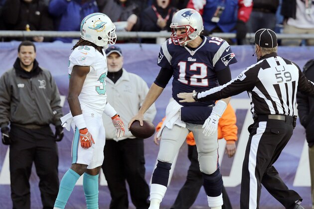 New England Patriots quarterback Tom Brady (12) has words with Miami Dolphins cornerback Walt Aikens (35), who tackled him in the second half of an NFL football game Sunday, Dec. 14, 2014, in Foxborough, Mass. (AP Photo/Charles Krupa)