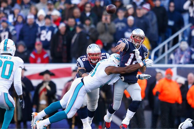 FOXBORO, MA - DECEMBER 14:  Tom Brady #12 of the New England Patriots is tackled during the second quarter against the Miami Dolphins at Gillette Stadium on December 14, 2014 in Foxboro, Massachusetts.  (Photo by Jim Rogash/Getty Images)