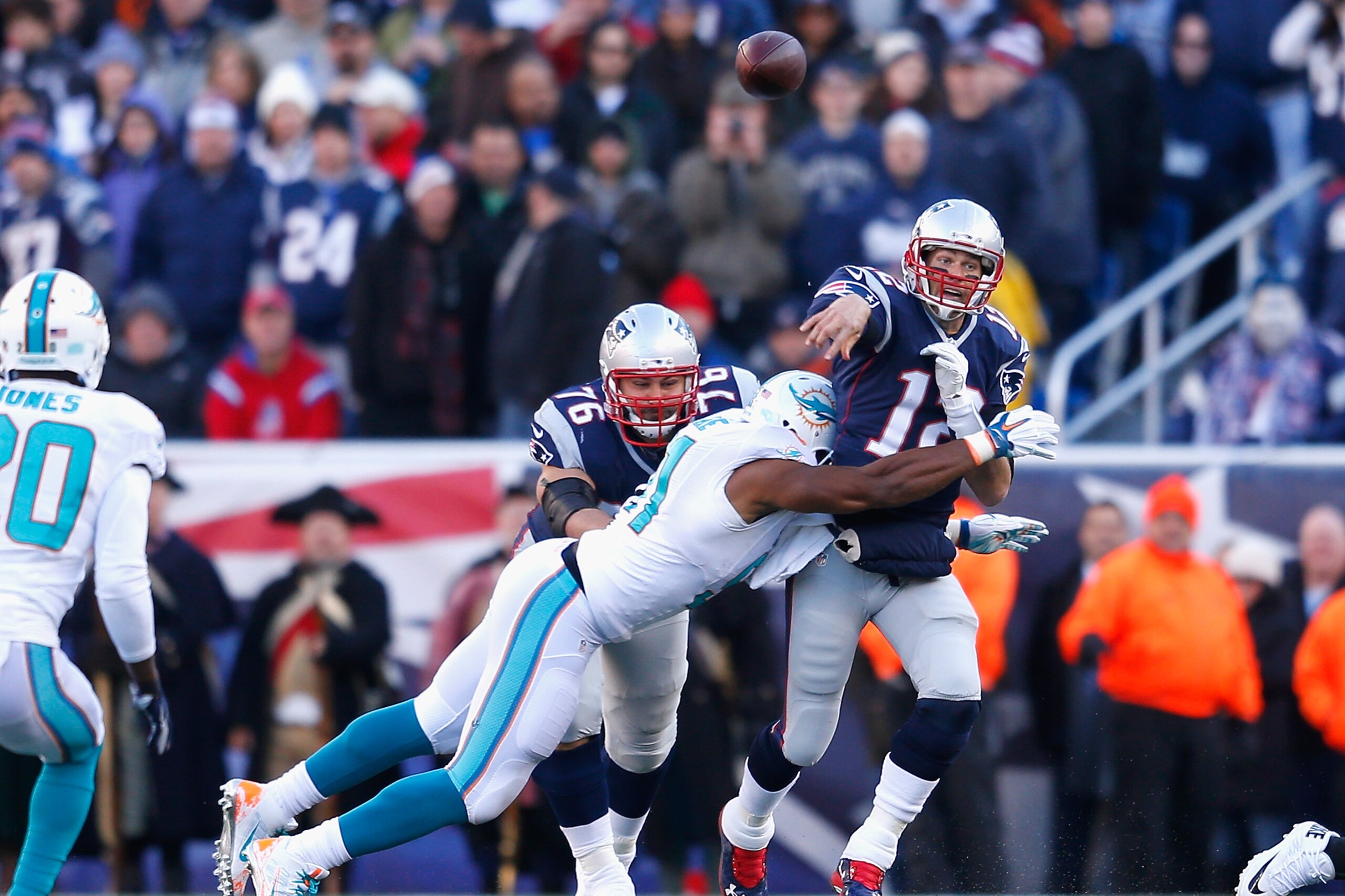 FOXBORO, MA - DECEMBER 14:  Tom Brady #12 of the New England Patriots is tackled during the second quarter against the Miami Dolphins at Gillette Stadium on December 14, 2014 in Foxboro, Massachusetts.  (Photo by Jim Rogash/Getty Images)