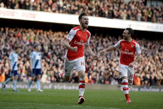 Arsenal's Aaron Ramsey, center, celebrates scoring his side's second goal during the English Premier League soccer match between Arsenal and West Ham United at the Emirates Stadium in London, Saturday, March 14, 2015.  (AP Photo/Matt Dunham)