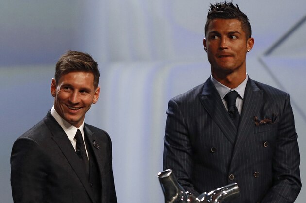 FC Barcelone Argentinian striker Lionel Messi (2ndR) shares a laugh with his Urugayan teammate Luis Suarez (2ndL) and Danish former football player and ceremony host Peter Schmeichel (L) eyed by Real Madrid's Portuguese striker Cristiano Ronaldo during the awarding ceremony for the Best Men's player in Europe at the end of the UEFA Champions League Group stage draw ceremony, on August 27, 2015 in Monaco. AFP PHOTO / VALERY HACHE        (Photo credit should read VALERY HACHE/AFP/Getty Images)