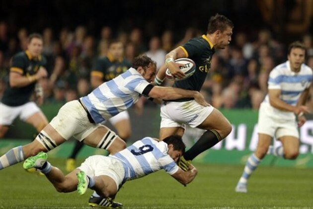 South Africa's Handre Pollard, right, is tackled from behind by Argentina's Tomas Cubelli, bottom, and teammate Leonardo Senatore, left, during their Rugby Championship match at Kings Park stadium Durban, South Africa on  Saturday, Aug. 8, 2015. (AP Photo/Themba Hadebe)