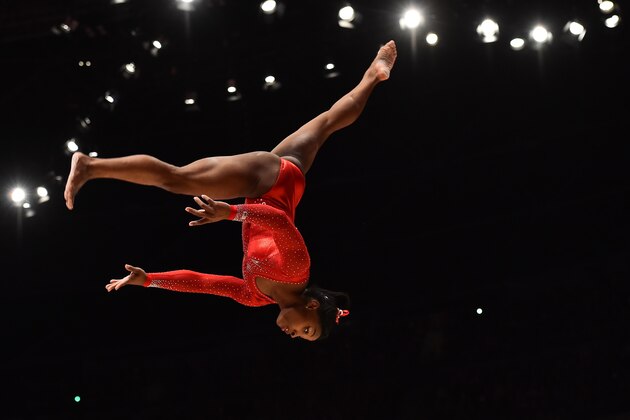 US gymnast Simone Biles competes on the balance beam during the Women's All-Around final on the seventh day of the 2015 World Gymnastics Championship in Glasgow, Scotland, on October 29, 2015. Gymnasts can secure qualification for the 2016 Rio Games at the championships which are being staged at the Hydro Arena.  AFP PHOTO / BEN STANSALL        (Photo credit should read BEN STANSALL/AFP/Getty Images)