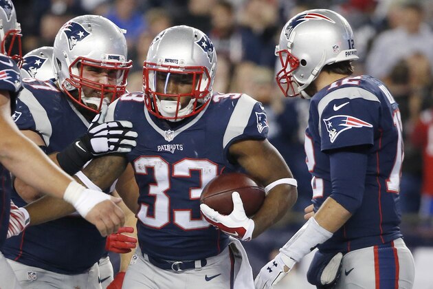 New England Patriots running back Dion Lewis (33) celebrates his touchdown with quarterback Tom Brady, right, and other teammates in the first half of an NFL football game against the Miami Dolphins, Thursday, Oct. 29, 2015, in Foxborough, Mass. (AP Photo/Michael Dwyer)