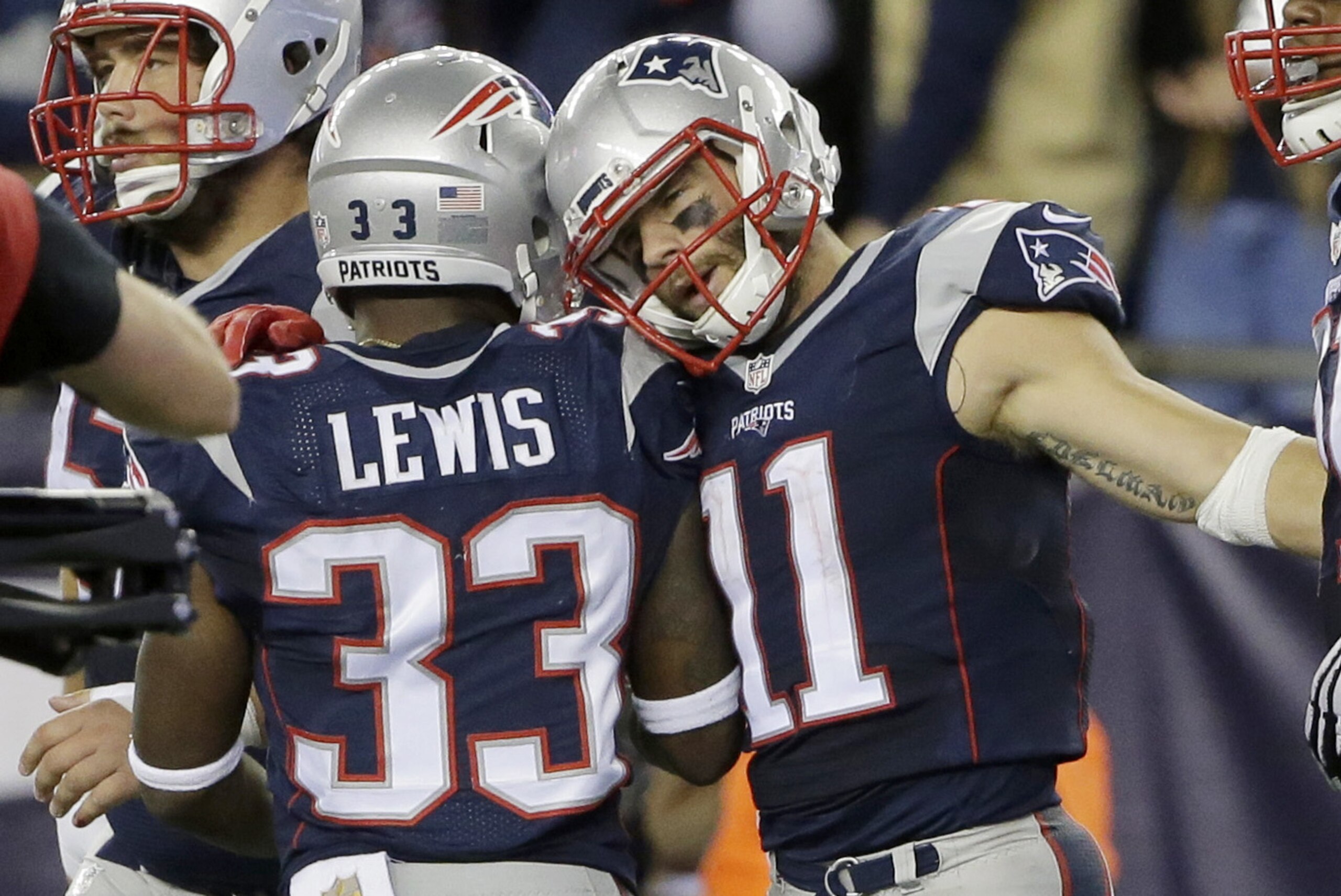 New England Patriots running back Dion Lewis (33) congratulates wide receiver Julian Edelman (11) on his touchdown in the second half of an NFL football game against the Miami Dolphins, Thursday, Oct. 29, 2015, in Foxborough, Mass. (AP Photo/Steven Senne)