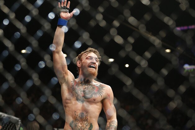 Conor McGregor celebrates between rounds against Chad Mendes during their interim featherweight title mixed martial arts bout at UFC 189 on Saturday, July 11, 2015, in Las Vegas. (AP Photo/John Locher)