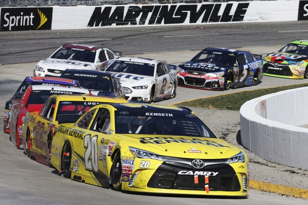 Matt Kenseth (20) leads the pack in Turn 4 during the NASCAR Sprint Cup Series auto race at Martinsville Speedway in Martinsville, Va., Sunday, March 29, 2015. (AP Photo/Steve Helber)