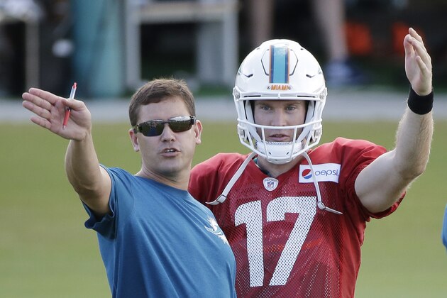 Miami Dolphins quarterback Ryan Tannehill (17) talks with offensive coordinator Bill Lazor during an NFL football training camp practice, Tuesday, Aug. 11, 2015 in Davie, Fla. (AP Photo/Wilfredo Lee)