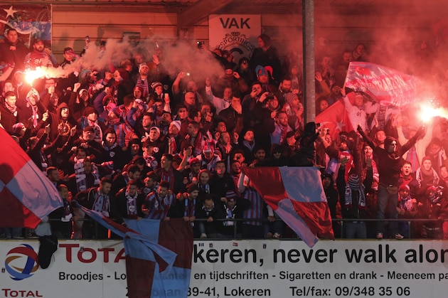 Fans wave flares during the Europa League Group L soccer match between Lokeren and Trabzonspor, in Lokeren, Belgium, Thursday, Nov. 6, 2014. (AP Photo/Yves Logghe)