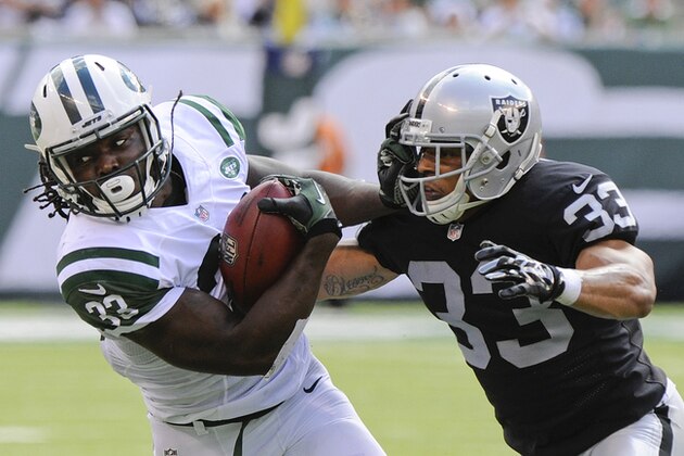 New York Jets running back Chris Ivory (33) stiff arms Oakland Raiders' Tyvon Branch (33) during the first half of an NFL football game Sunday, Sept. 7, 2014, in East Rutherford, N.J. (AP Photo/Bill Kostroun)