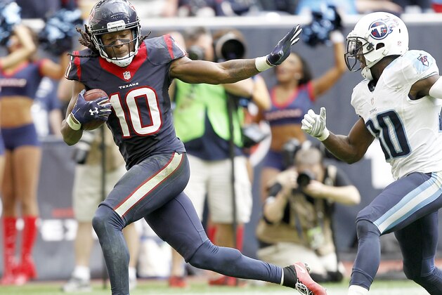 HOUSTON, TX - NOVEMBER 30: DeAndre Hopkins #10 of the Houston Texans stiff arms Jake Locker #10 of the Tennessee Titans in the fourth quarter in a NFL game on November 30, 2014 at NRG Stadium in Houston, Texas. (Photo by Bob Levey/Getty Images)