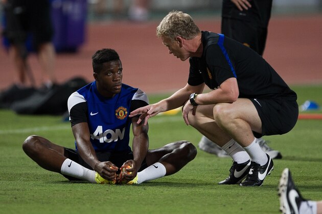 Manchester United football manager David Moyes (R) talks with football player Wilfried Zaha (L) during a training session at the Rajamangala stadium in Bangkok on July 12, 2013. Wayne Rooney said he was 'gutted' after a hamstring injury forced him out of Manchester United's Asian tour on the very first day with questions still unanswered about his future. AFP PHOTO/ Nicolas ASFOURI        (Photo credit should read NICOLAS ASFOURI/AFP/Getty Images)