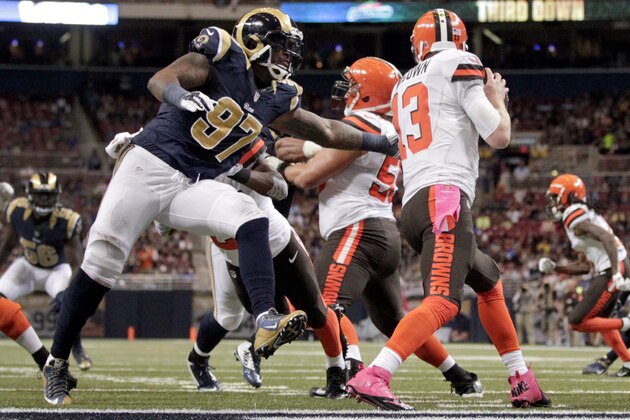 Cleveland Browns quarterback Josh McCown (13) looks to throw under pressure from St. Louis Rams defensive end Eugene Sims (97) during the second quarter of an NFL football game Sunday, Oct. 25, 2015, in St. Louis. (AP Photo/Tom Gannam)