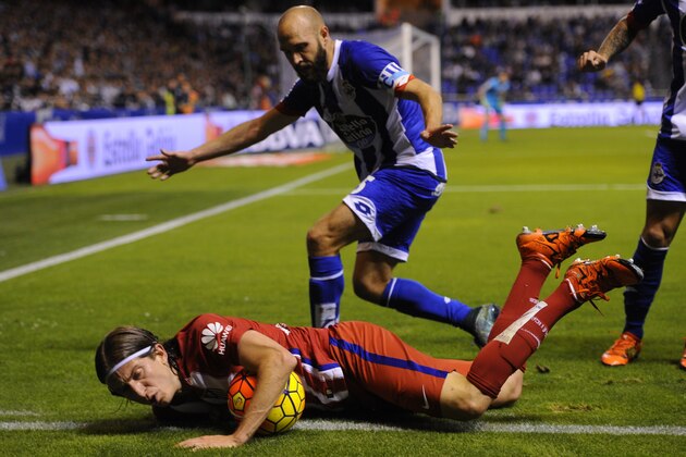 Atletico Madrid's Brazilian defender Filipe Luis (down) falls next to Deportivo La Coruna's defender Laure during the Spanish league football match RC Deportivo La Coruna vs Club Atletico de Madrid at the Municipal de Riazor stadium in La Coruna on October 30, 2015.  AFP PHOTO / MIGUEL RIOPA        (Photo credit should read MIGUEL RIOPA/AFP/Getty Images)