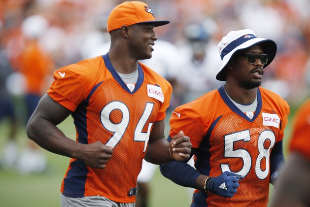 Denver Broncos defensive end DeMarcus Ware, left, and outside linebacker Von Miller run between stations to watch drills at the team's NFL football training camp Monday, Aug. 3, 2015, in Englewood, Colo. (AP Photo/David Zalubowski)