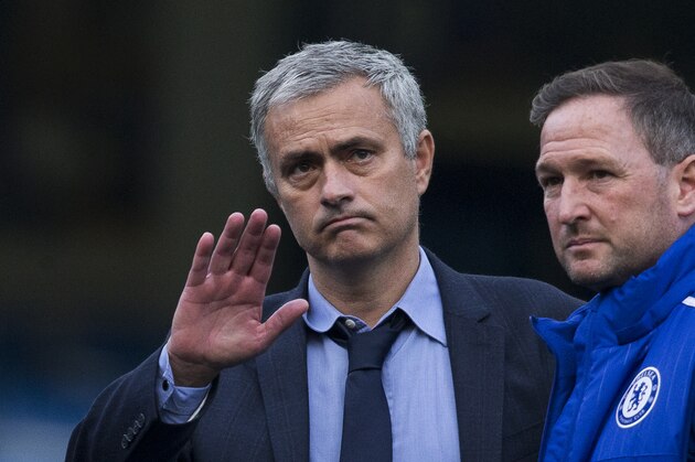 Chelsea's head coach Jose Mourinho waves at fans as he talks with his coaching staff after coming back out onto the pitch after the English Premier League soccer match between Chelsea and Liverpool at Stamford Bridge stadium in London, Saturday, Oct. 31, 2015.  Liverpool won the match 3-1.  (AP Photo/Matt Dunham)