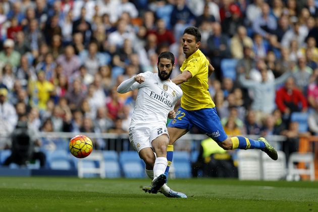 Real Madrid's Francisco Roman “Isco”, left, scores the opening goal past Las Palmas' Javi Garrido during the Spanish La Liga soccer match between Real Madrid and Las Palmas at the Santiago Bernabeu stadium in Madrid, Saturday, Oct. 31, 2015. (AP Photo/Francisco Seco)