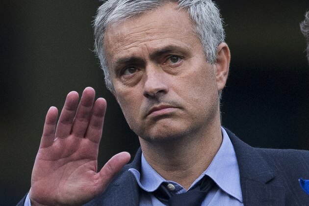 Chelsea's head coach Jose Mourinho waves at fans as he talks with his coaching staff after coming back out onto the pitch after the English Premier League soccer match between Chelsea and Liverpool at Stamford Bridge stadium in London, Saturday, Oct. 31, 2015.  Liverpool won the match 3-1.  (AP Photo/Matt Dunham)