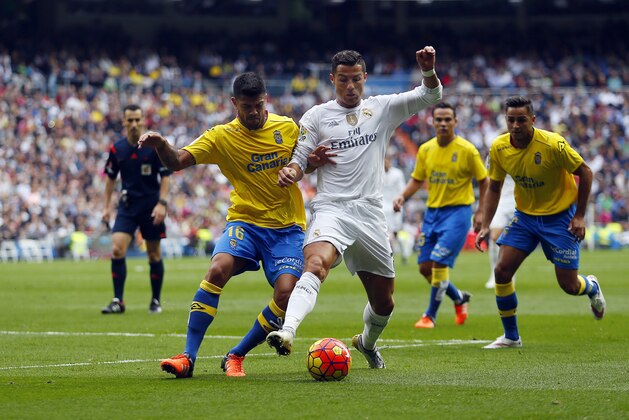 Real Madrid's Cristiano Ronaldo, right, tussles for the ball with Las Palmas' Aythami Artiles during the Spanish La Liga soccer match between Real Madrid and Las Palmas at the Santiago Bernabeu stadium in Madrid, Saturday, Oct. 31, 2015. Ronaldo scored once in Real Madrid's 3-1 victory. Ronaldo scored once in Real Madrid's 3-1 victory. (AP Photo/Francisco Seco)