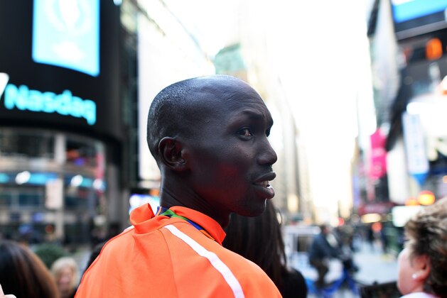 2014 New York City Marathon men's winner Kenyans Wilson Kipsang smiles as he poses with tourists in Times Square in New York on November 3, 2014. Kipsang, making his New York debut, held off Lelisa Desisa to win in an official time of two hours 10 minutes and 55 seconds, defeating the Ethiopian by 11 seconds with Ethiopia's Gebre Gebremariam third in 2:12:13. Kipsang looked Desisa in the eyes in the final stretch and then pulled away to claim the $100,000 (80,000 euro) top prize and take the 2013-14 World Marathon Majors bonus top prize of $500,000 (400,000 euros). AFP PHOTO/Jewel Samad        (Photo credit should read JEWEL SAMAD/AFP/Getty Images)