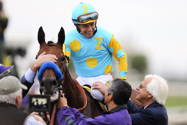 Jockey Victor Espinoza is congratulated by trainer Bob Baffert, right, as American Pharoah is led to the winner's circle after winning the Breeders' Cup Classic horse race at Keeneland race track Saturday, Oct. 31, 2015, in Lexington, Ky. (AP Photo/Garry Jones)
