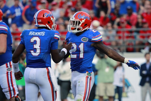Oct 31, 2015; Jacksonville, FL, USA; Florida Gators running back Kelvin Taylor (21) is congratulated by  quarterback Treon Harris (3) as he scores a touchdown against the Georgia Bulldogs during the second quarter at  EverBank Stadium. Mandatory Credit: Kim Klement-USA TODAY Sports
