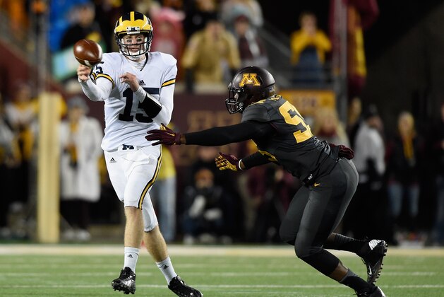 MINNEAPOLIS, MN - OCTOBER 31: Jake Rudock #15 of the Michigan Wolverines looks to pass the ball under pressure from Theiren Cockran #55 of the Minnesota Golden Gophers during the second quarter of the game on October 31, 2015 at TCF Bank Stadium in Minneapolis, Minnesota. (Photo by Hannah Foslien/Getty Images)