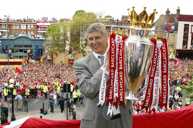 Arsenal manager Arsene Wenger holds up the English Premiership Trophy outside Islington Town Hall in North London, Sunday May 16, 2004, during their victory parade. (AP Photo/Lawrence Lustig, Pool)