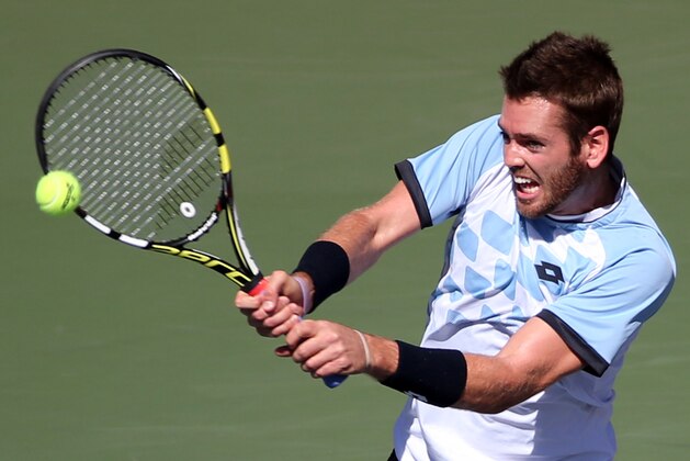 Austin Krajicek, of the United States, returns a shot against Joao Sousa of Portugal during their second round singles match at the Japan Open men’s tennis tournament in Tokyo, Thursday, Oct. 8, 2015. (AP Photo/Eugene Hoshiko)