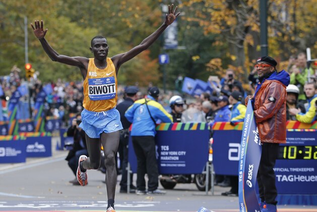 Stanley Biwott of Kenya reacts with film director Spike Lee, right, watching after Biwott won the professional men's athlete division in the the New York City marathon, Sunday, Nov. 1, 2015 in New York.  (AP Photo/Kathy Willens)