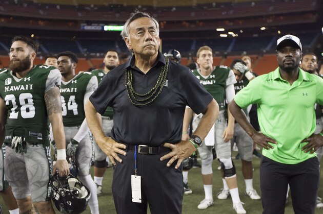 Hawaii coach Norm Chow stands with players and other team members after Air Force defeated Hawaii 58-7 in an NCAA college football game, Saturday, Oct. 31, 2015, in Honolulu. (AP Photo/Eugene Tanner)