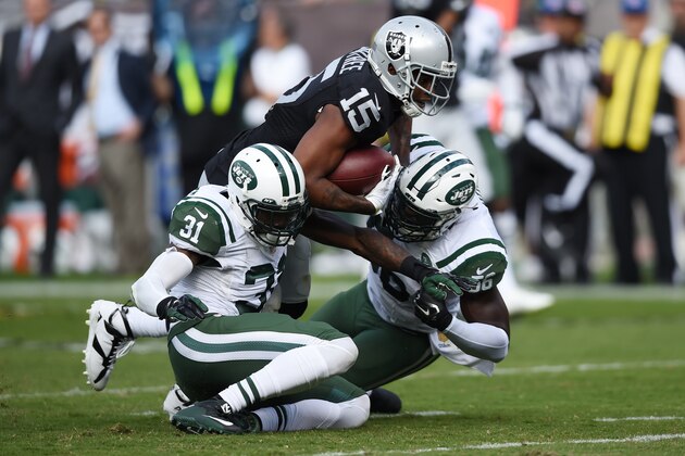 OAKLAND, CA - NOVEMBER 01:  Michael Crabtree #15 of the Oakland Raiders breaks a tackle from Demario Davis #56 and Antonio Cromartie #31 of the New York Jets as he runs for a 36-yard touchdown reception against the New York Jets during their NFL game at O.co Coliseum on November 1, 2015 in Oakland, California.  (Photo by Thearon W. Henderson/Getty Images)