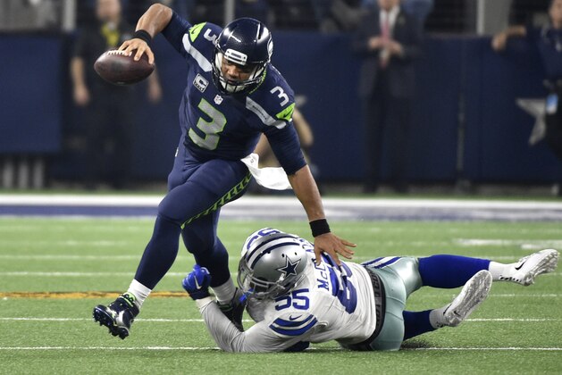 Seattle Seahawks' Russell Wilson (3) breaks away from a tackle-attempt by Dallas Cowboys' Rolando McClain (55) in the second half of an NFL football game Sunday, Nov. 1, 2015, in Arlington, Texas. (AP Photo/Michael Ainsworth)