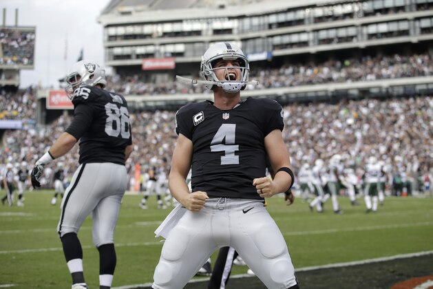 Oakland Raiders quarterback Derek Carr (4) reacts after throwing a touchdown pass to wide receiver Andre Holmes during the first half of an NFL football game against the New York Jets in Oakland, Calif., Sunday, Nov. 1, 2015. (AP Photo/Marcio Jose Sanchez)