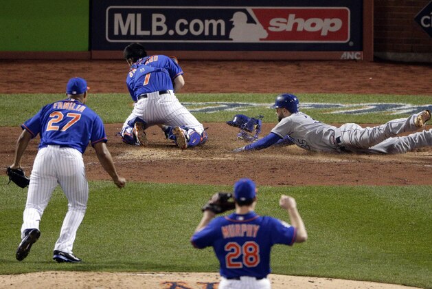 Kansas City Royals' Eric Hosmer right, scores past New York Mets catcher Travis d'Arnaud as relief pitcher Jeurys Familia (27) and second baseman Daniel Murphy (28) look on during the ninth inning of Game 5 of the Major League Baseball World Series Sunday, Nov. 1, 2015, in New York. (AP Photo/Charlie Riedel)