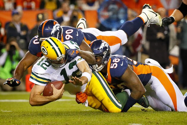 Green Bay Packers quarterback Aaron Rodgers (12) is sacked by Denver Broncos defensive end Antonio Smith (90) and outside linebacker Von Miller (58) during the second half of an NFL football game, Sunday, Nov. 1, 2015, in Denver. (AP Photo/Jack Dempsey)