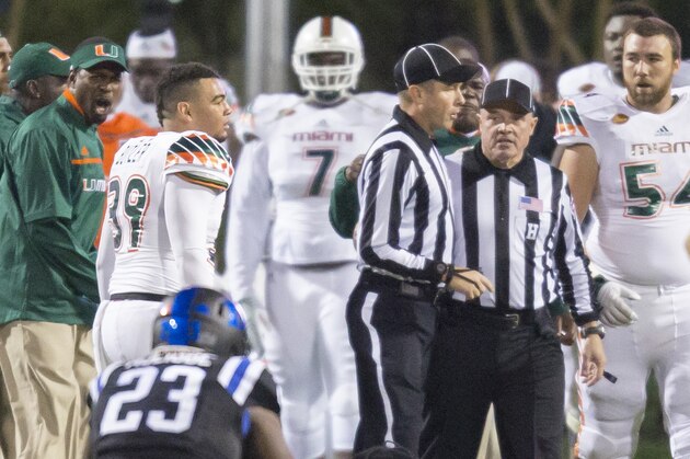 Officials confer on the field following a controversial kickoff return, with eight laterals, that ended in a touchdown to end the game and give Miami the win, 30-27, over Duke in an NCAA college football game, in Durham, N.C., Saturday, Oct. 31, 2015. A penalty for a block in the back was called during the play, and one player appeared to be down before a lateral, but the play was allowed to stand as a touchdown. On Sunday, Nov. 1, 2015, the ACC announced that the officiating and replay crew has been suspended for two games for mistakes made during the play. (AP Photo/Rob Brown)