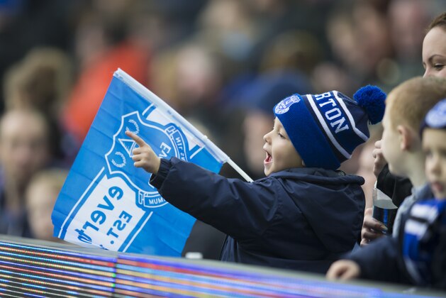 A young Everton supporter holds a flag before the English Premier League soccer match between Everton and Sunderland at Goodison Park Stadium, Liverpool, England, Sunday Nov.1,  2015. (AP Photo/Jon Super)