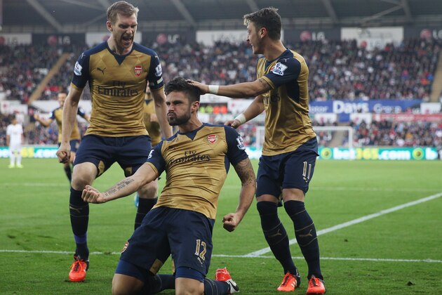 SWANSEA, WALES - OCTOBER 31: Olivier Giroud (C) of Arsenal celebrates scoring his team's first goal  with his team mates Per Mertesacker (L) and Mesut Ozil (R) during the Barclays Premier League match between Swansea City and Arsenal at Liberty Stadium on October 31, 2015 in Swansea, Wales.  (Photo by Ben Hoskins/Getty Images)