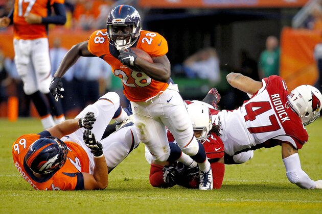 Denver Broncos running back Montee Ball (28) is tripped up by Arizona Cardinals defensive end Ed Stinson (72) during the first half of an NFL preseason football game, Thursday, Sept. 3, 2015, in Denver. (AP Photo/Jack Dempsey)