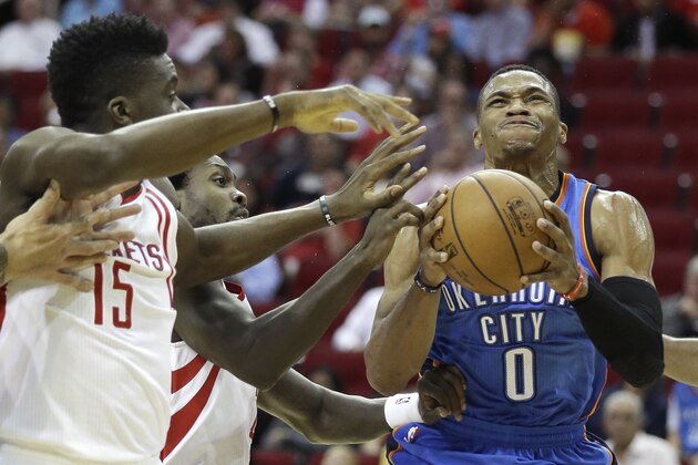 Oklahoma City Thunder's Russell Westbrook (0) looks to shoot as Houston Rockets Clint Capela (15) and Patrick Beverley defend in the first half of an NBA basketball game Monday, Nov. 2, 2015, in Houston. (AP Photo/Pat Sullivan)