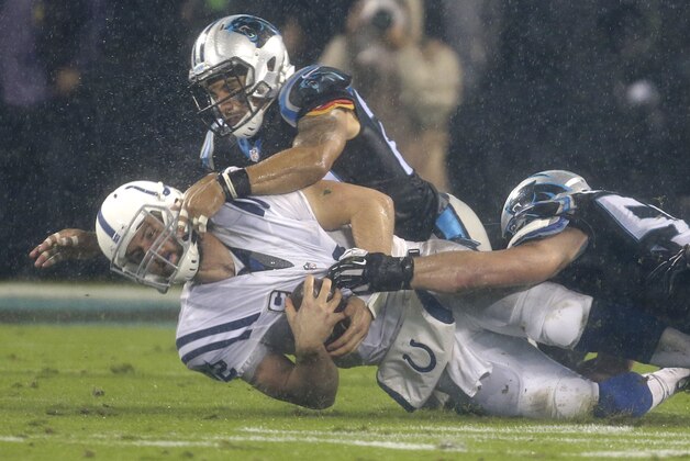 Indianapolis Colts' Andrew Luck, center, is tackled by Carolina Panthers' Luke Kuechly, right, and Kurt Coleman, left, in the first half of an NFL football game in Charlotte, N.C., Monday, Nov. 2, 2015. (AP Photo/Bob Leverone)